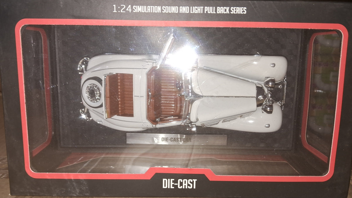 A 1:24 scale die-cast model car in its original black packaging box with red trim, displayed on a cardboard surface.
